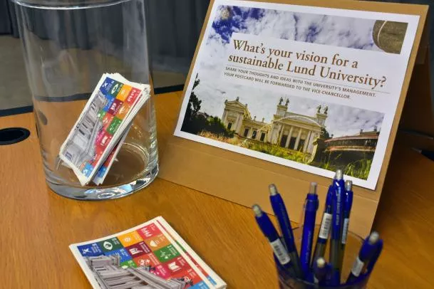 Postcards, pens and a sign that says "A sustainable Lund University". Photo.