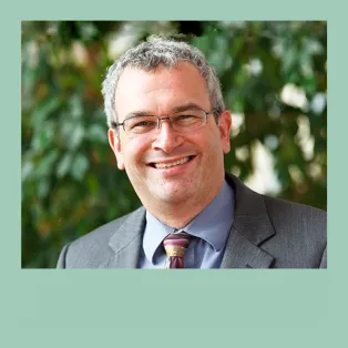 Portrait of David Reinier who is smiling towards the camera. Photo.